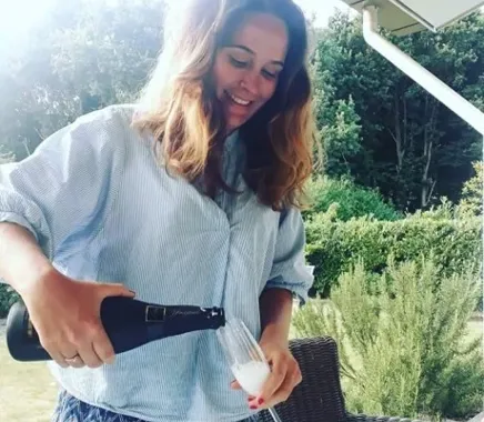 Eveline with a glass of champagne after the purchase of a new house